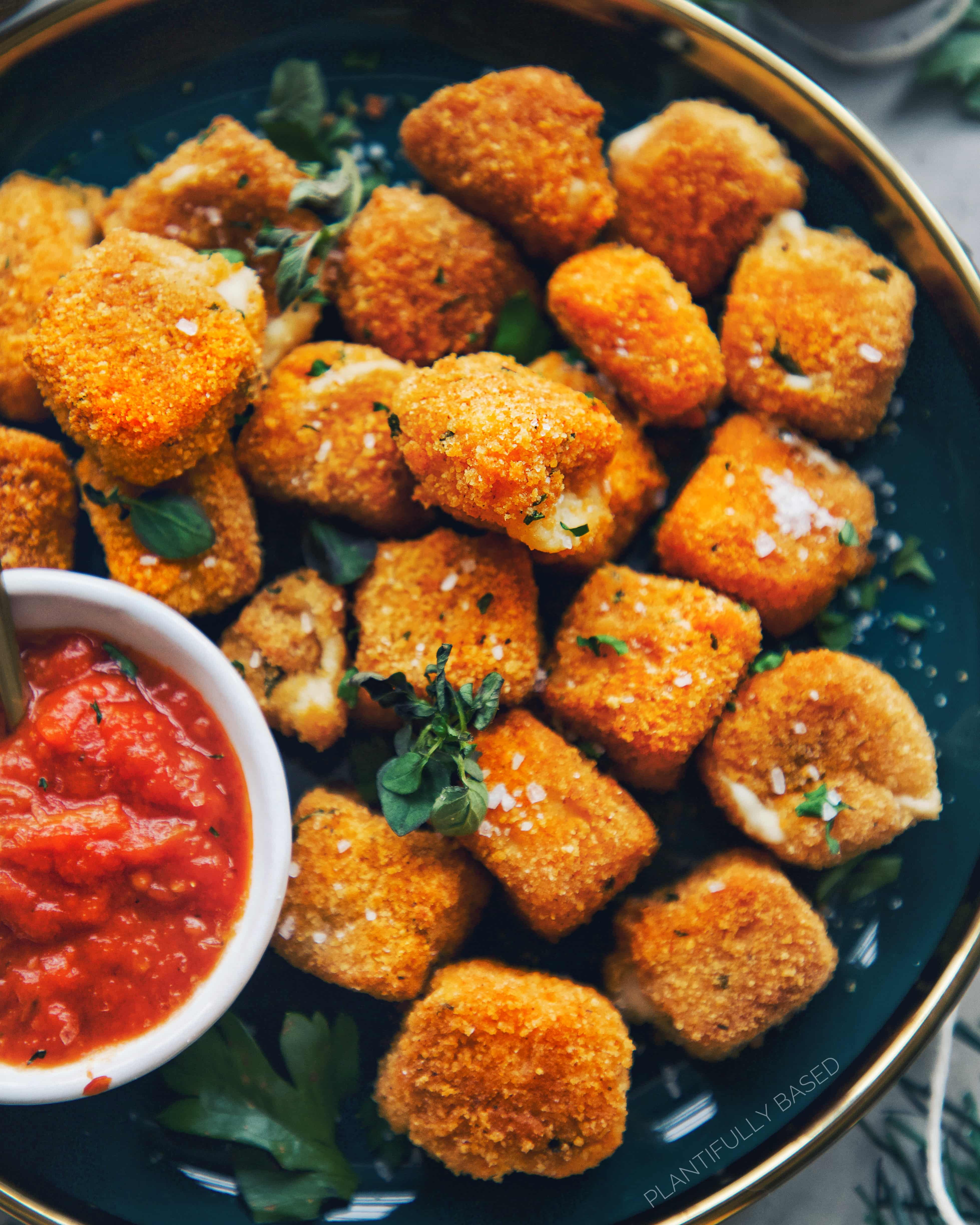 picture of air fried vegan mozzarella bites all on a blue dish
