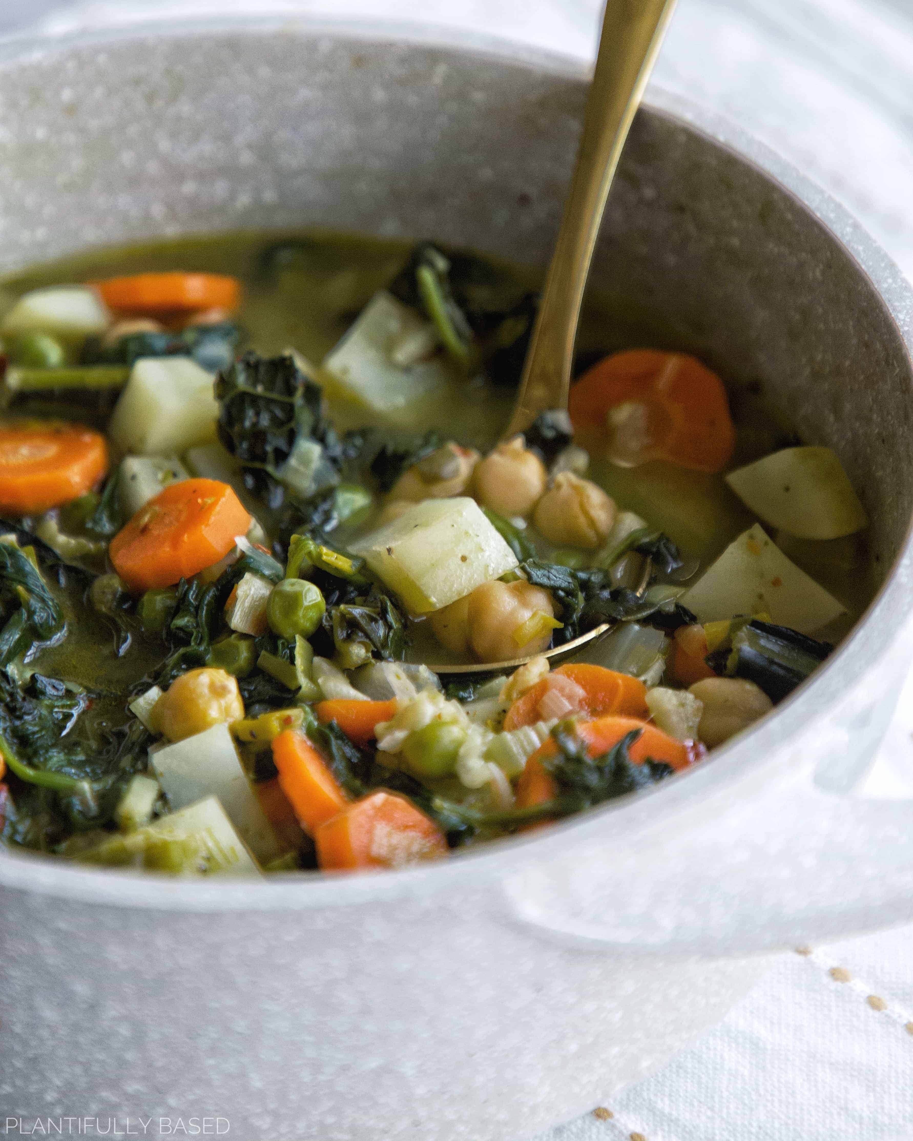 picture of spring green minestrone soup in light grey pot it was cooked in with golden ladle