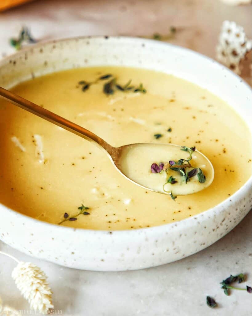 image of cheesy cauliflower soup with gold spoon