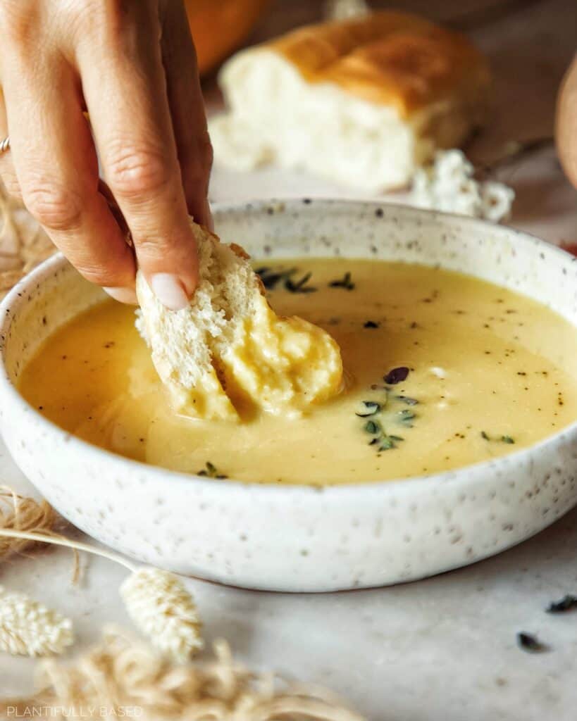 image of bread being dipped in cheesy cauliflower soup
