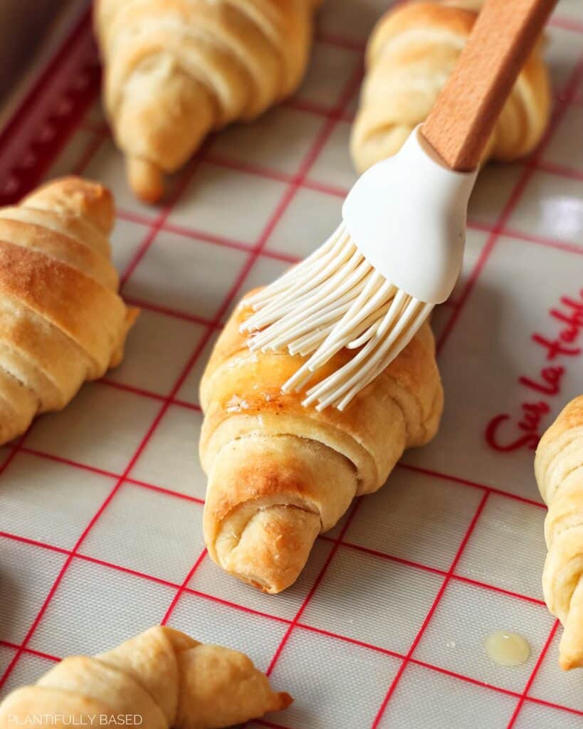 image of crescent rolls being brushed with melted vegan butter