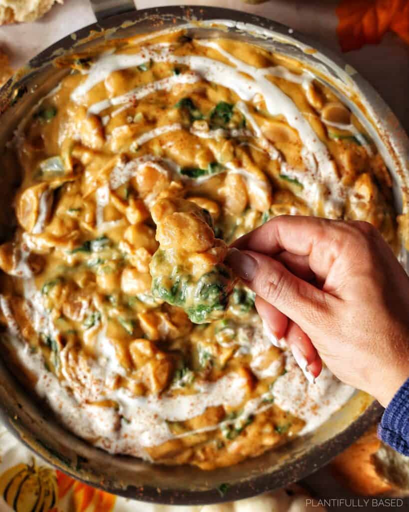 image of the butternut squash butter beans with hand scooping bread
