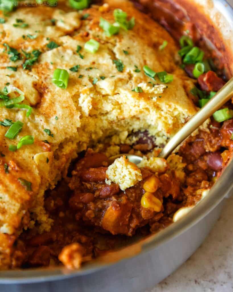 image of cornbread chili casserole being scooped in pan