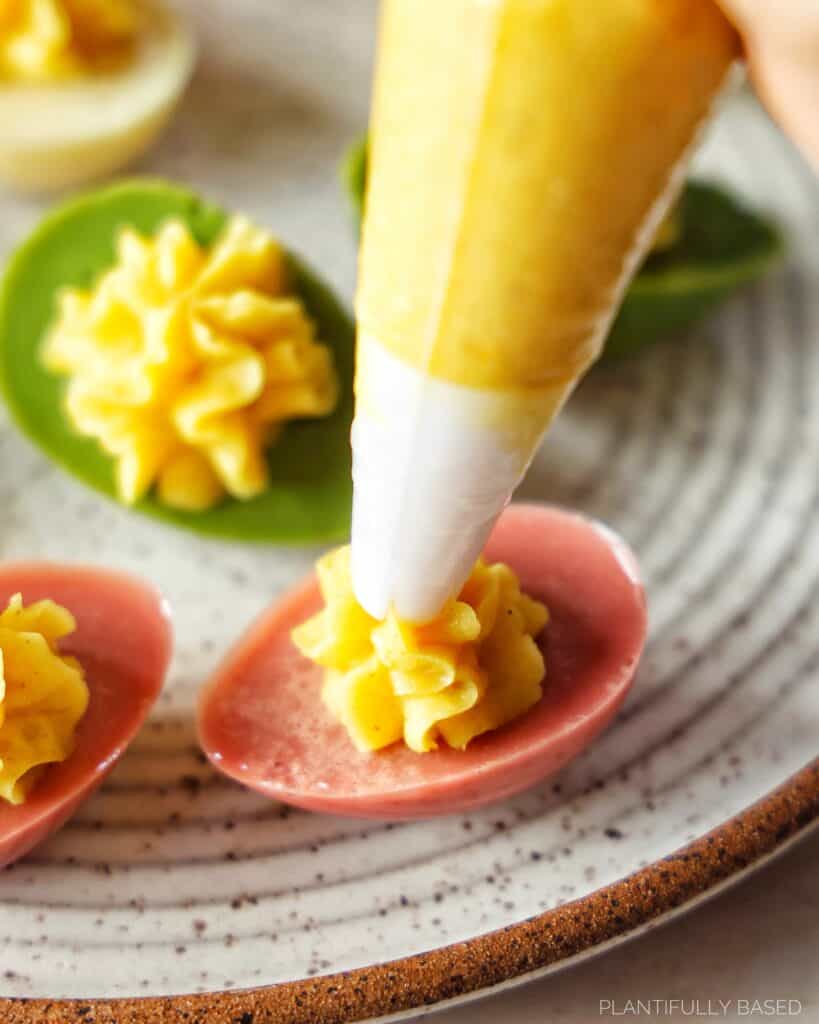 image of colorful vegan deviled eggs with piping filling