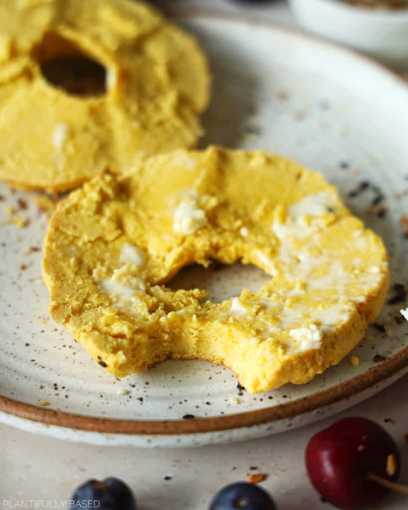high protein gluten free bagel cut in half with vegan butter