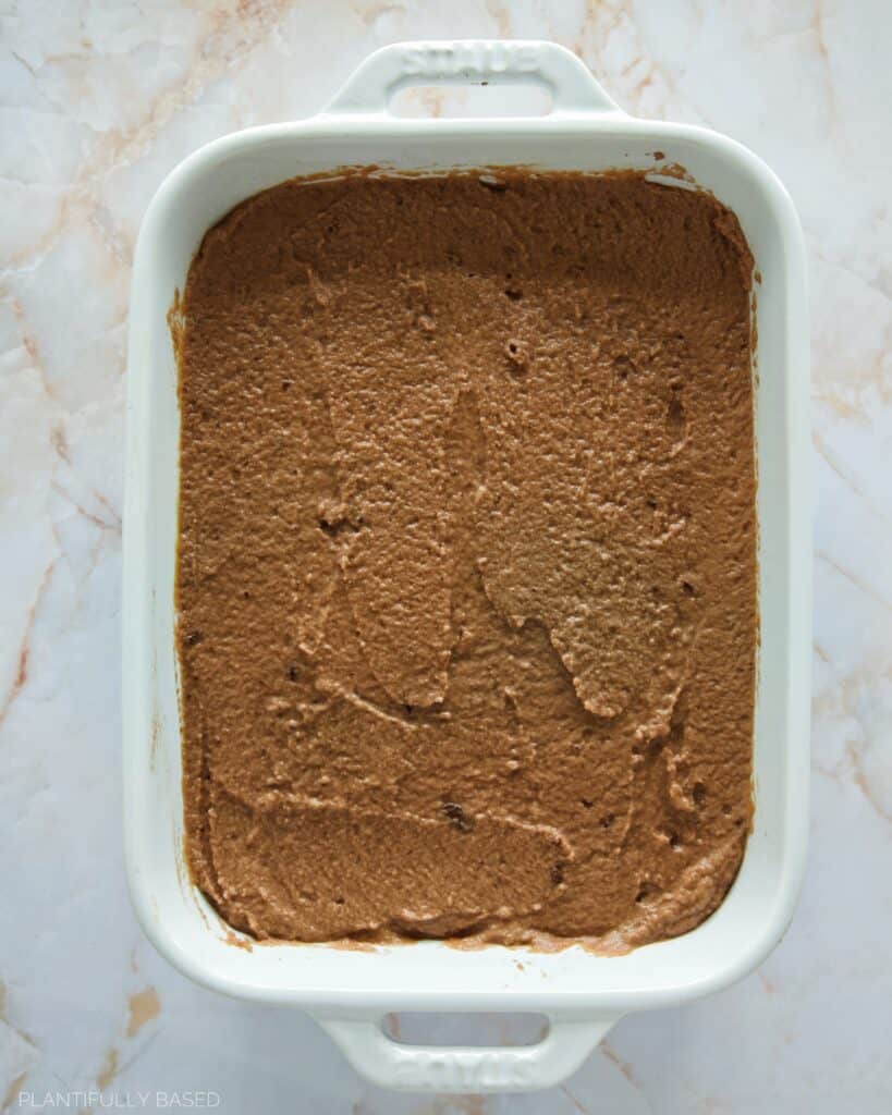 brownie batter spread out in a dish before baking