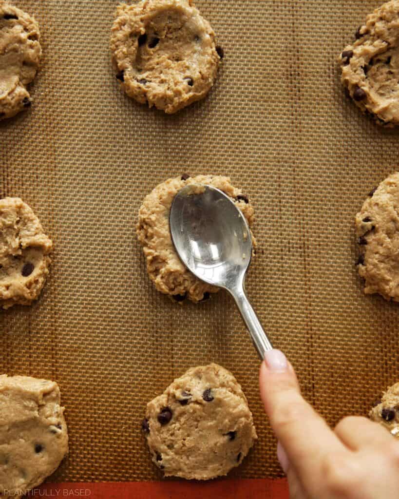 image of Tofu Chocolate Chip Cookies made with Silken Tofu cookie dough being pressed down with spoon