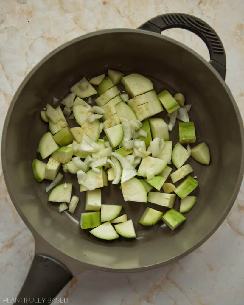 cooking zucchini, onion, garlic in a pan