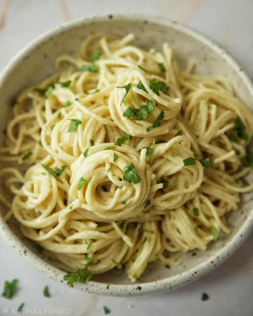 vegan alfredo sauce on pasta in a bowl