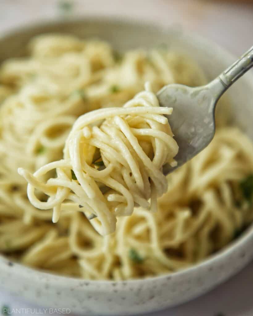 vegan alfredo sauce on pasta on a fork