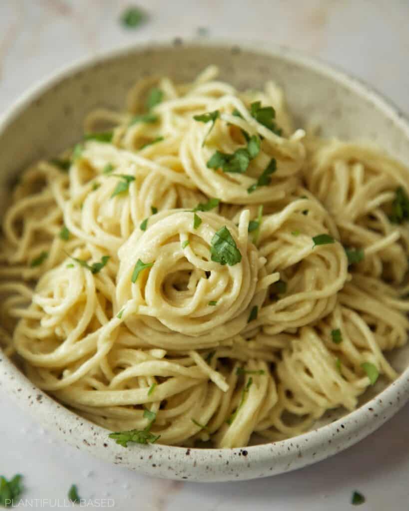 vegan alfredo sauce on pasta in a bowl