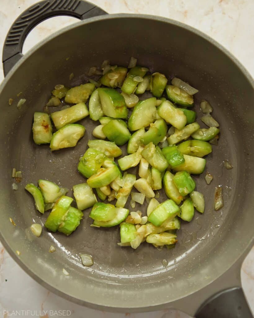 cooking zucchini, onion, garlic in a pan