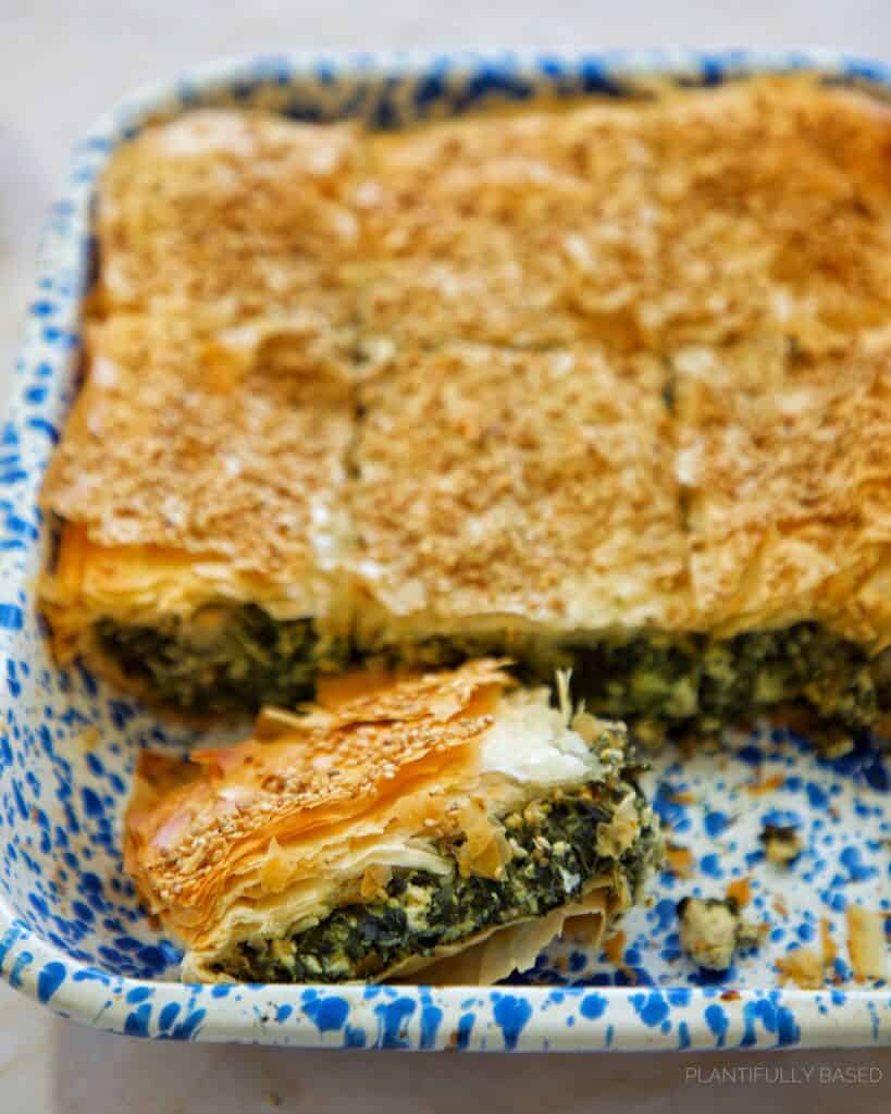 spinach pie cut up in a pan