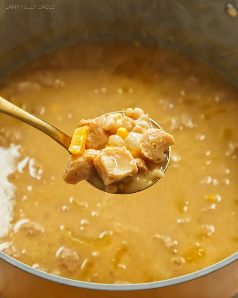 spoon holding vegan white chicken chili in pot
