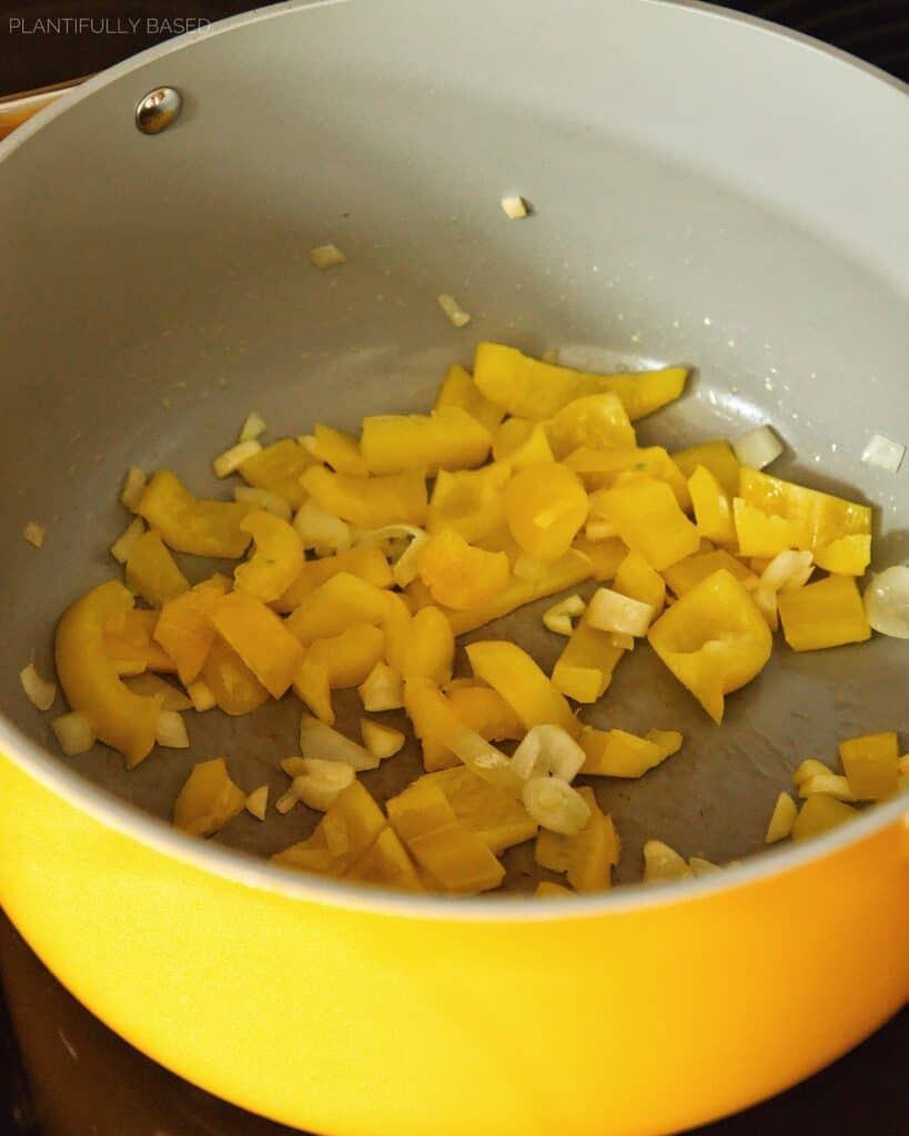 cooking onion, garlic, and bell pepper in pot