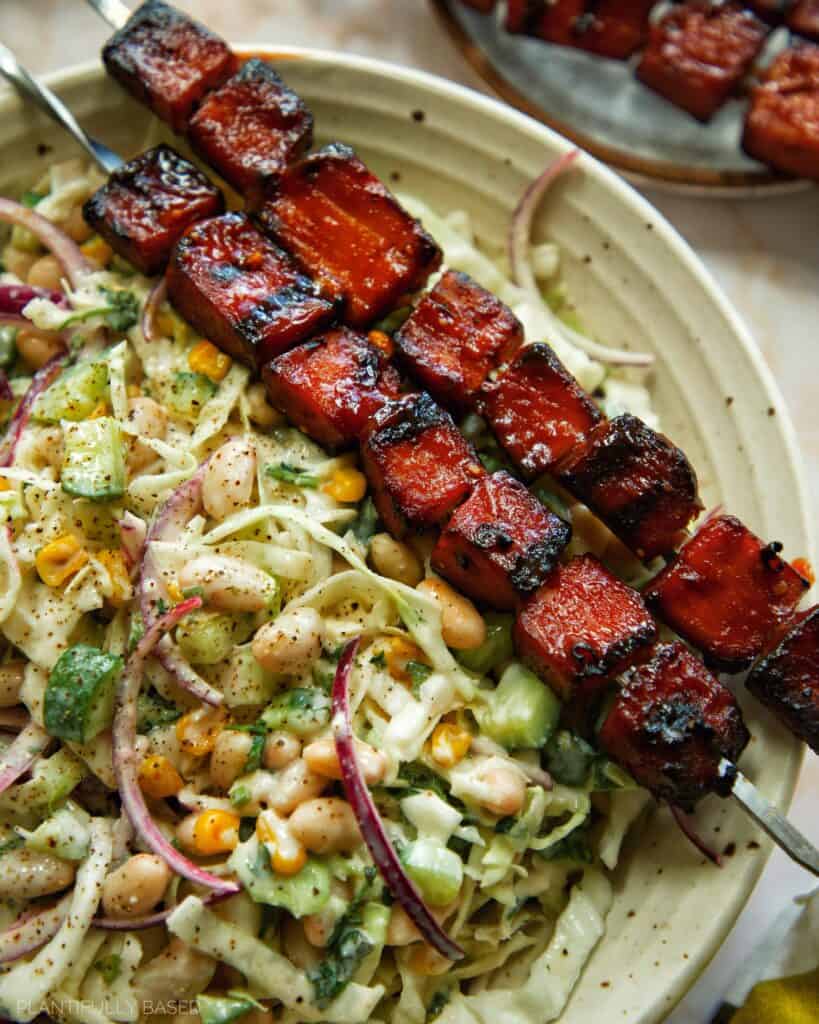tofu skewers with cabbage salad in a bowl