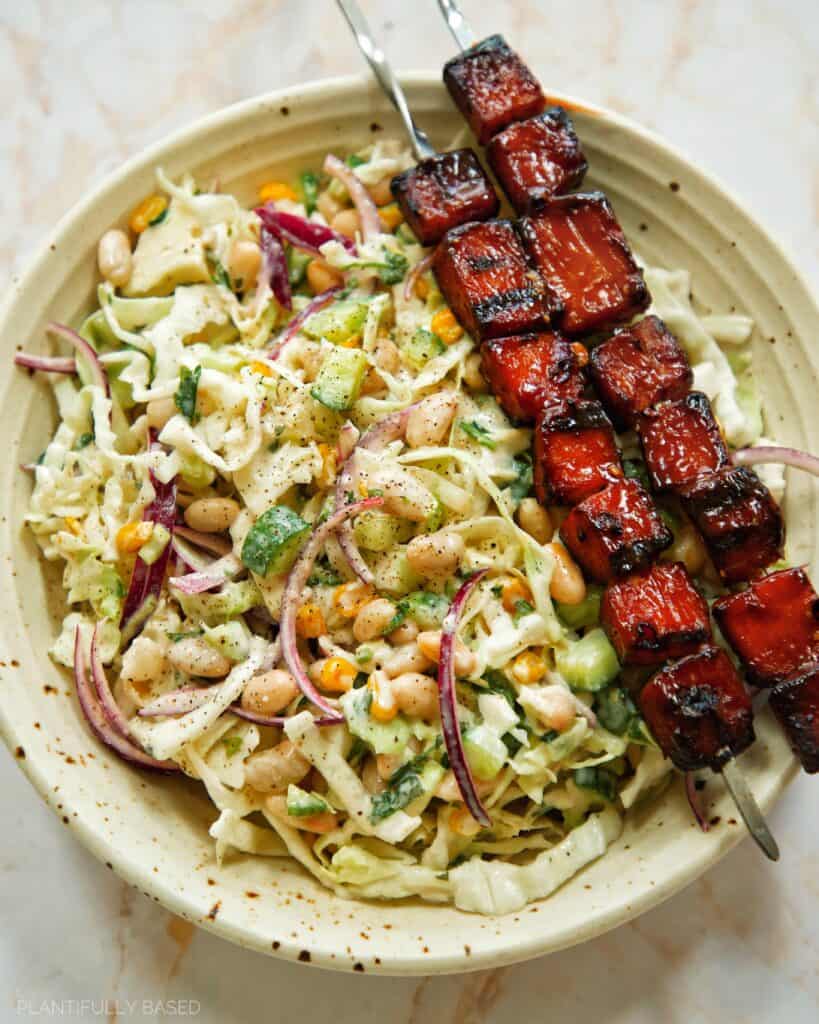 tofu skewers with cabbage salad in a bowl